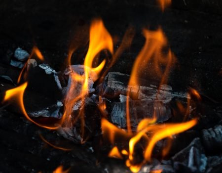 Backyard outdoor fireplace full of burning embers.